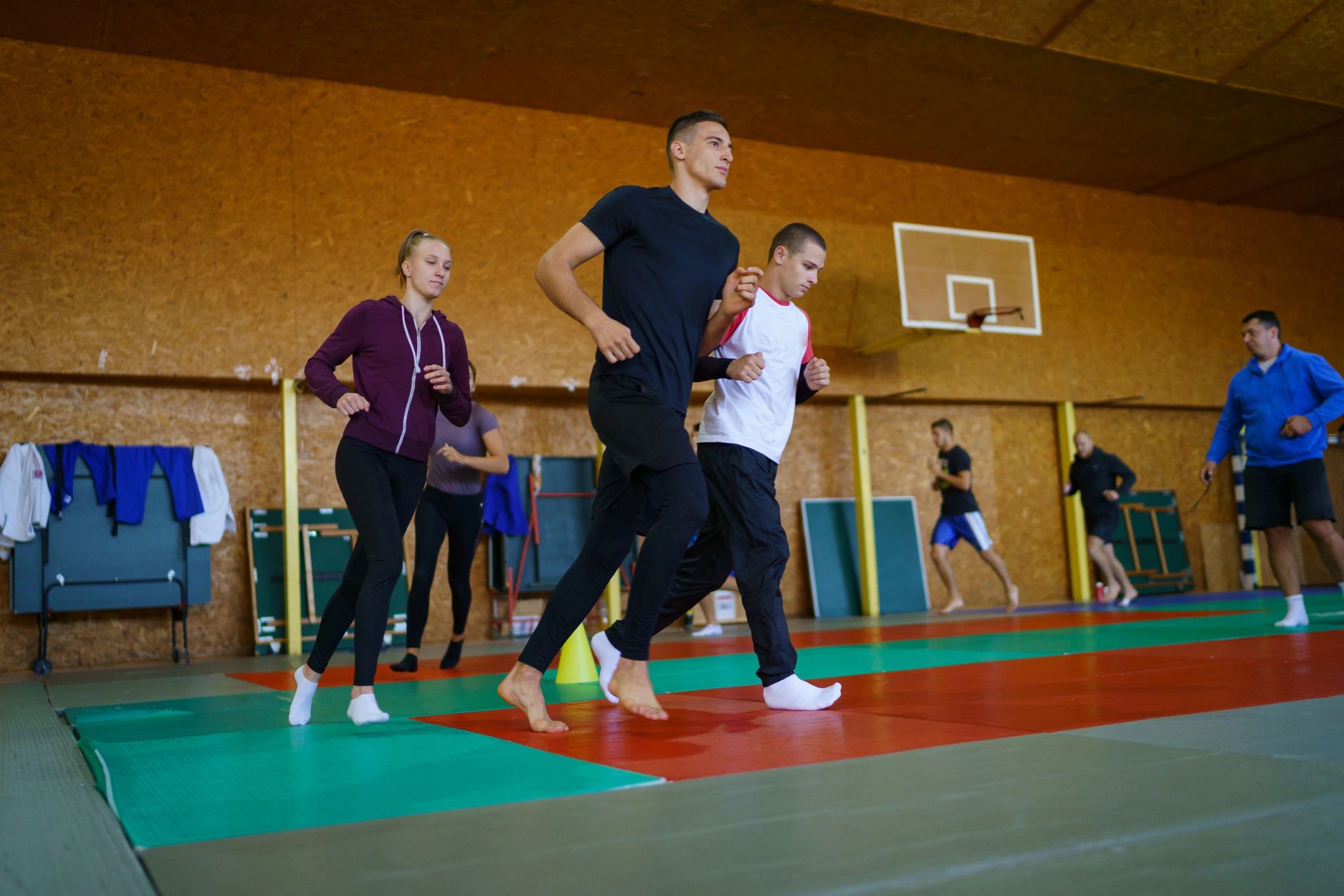 Group of young athletes warming up indoors