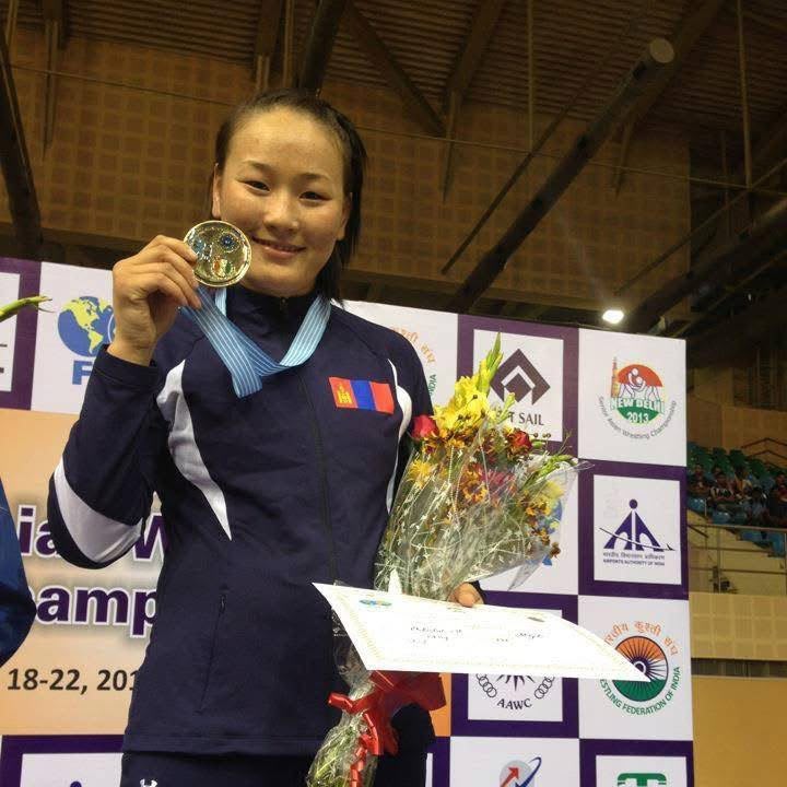 Coach Uka with a medal, flowers and certificate