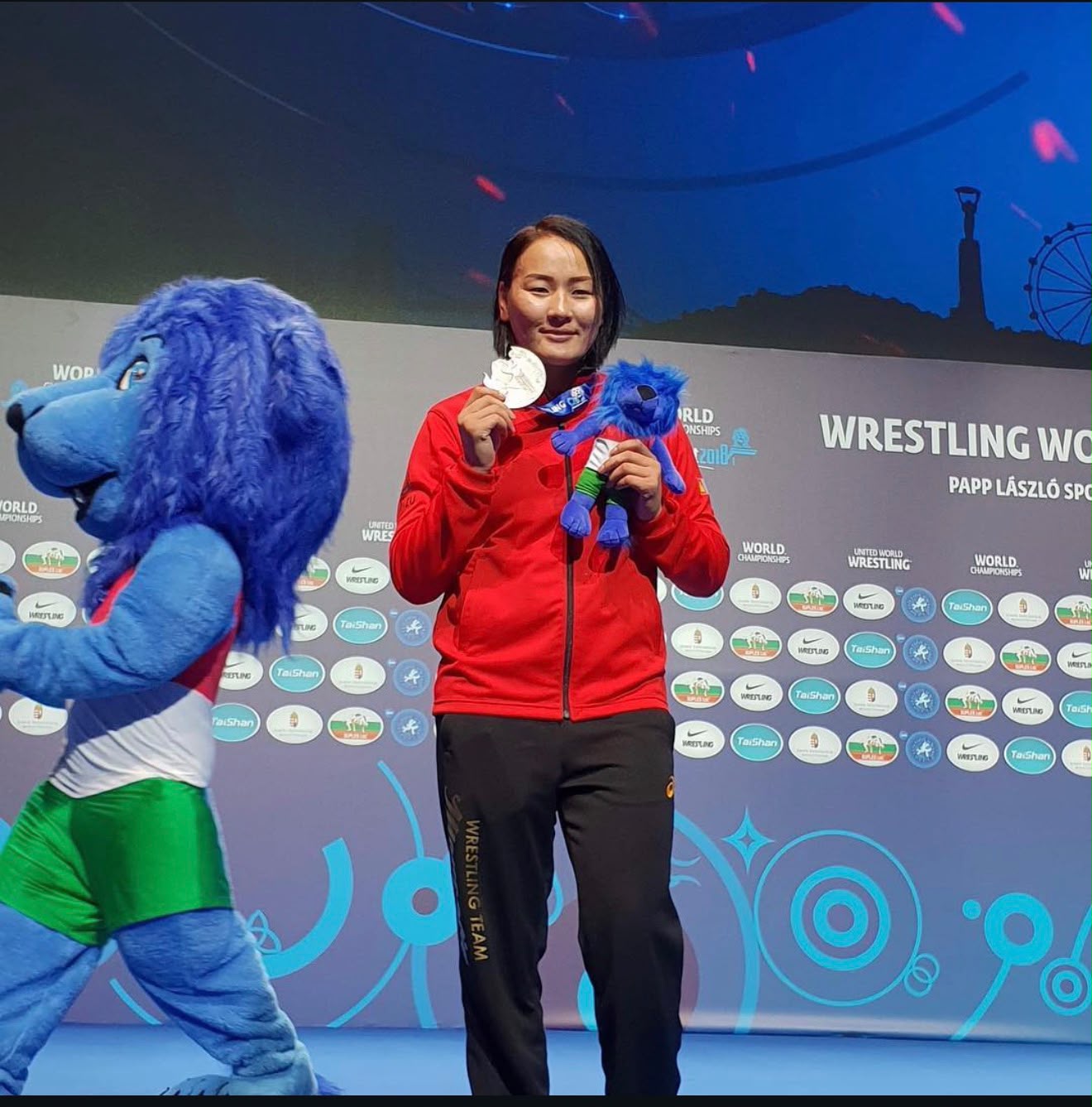 Coach Uka holding a World Championships medal