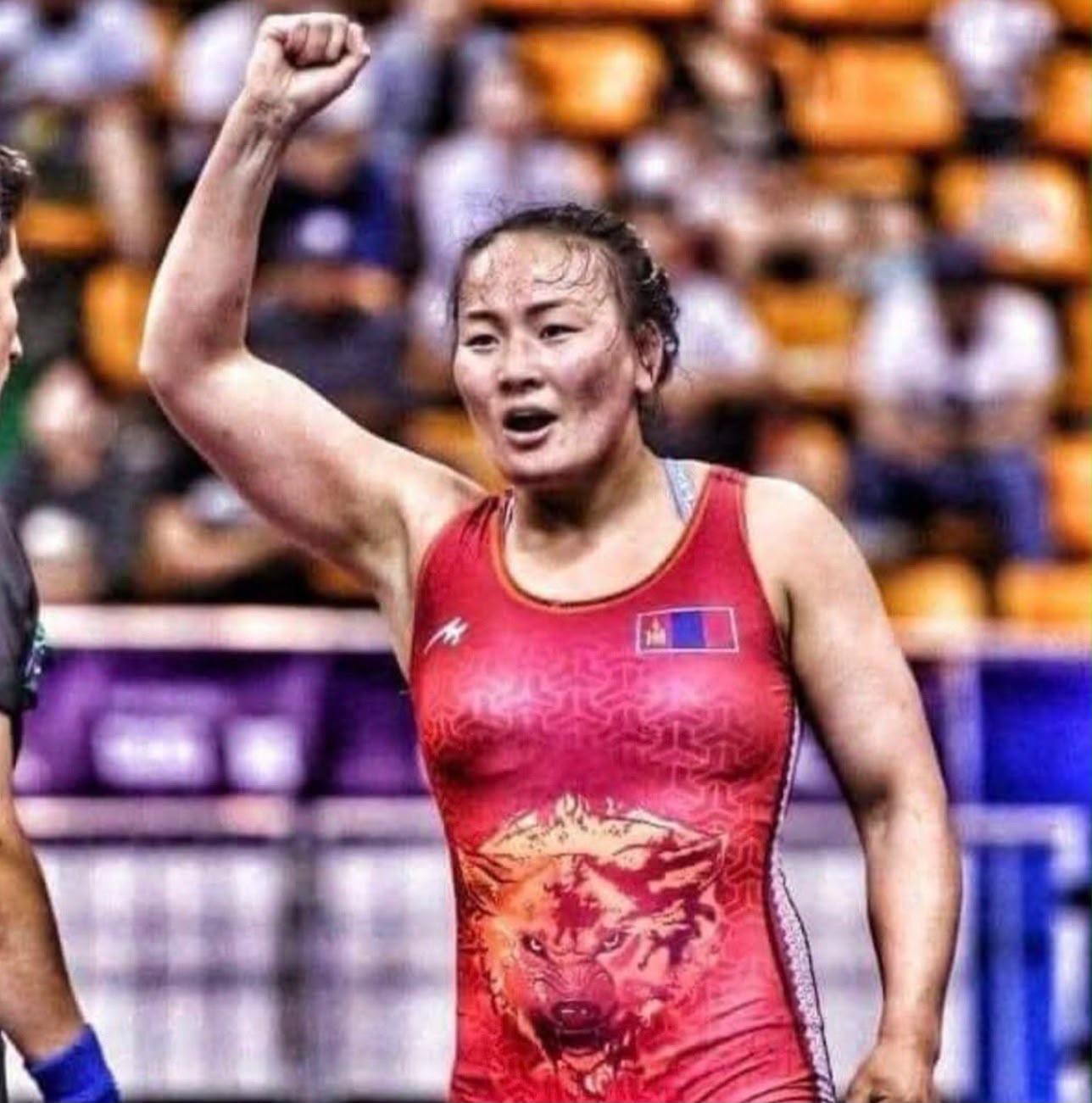 Coach Uka raising her fist after a wrestling match